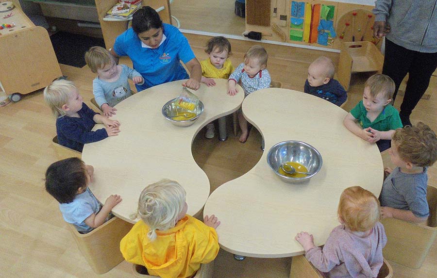 Childern at a table learning with their teacher